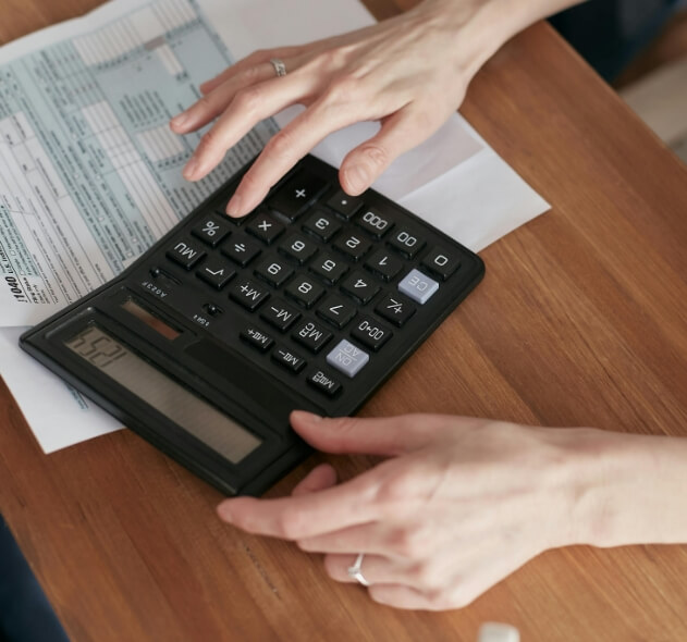 calculadora negra con manos de mujer controlando y realizando estrategia de negocio-Marinetto Asesores